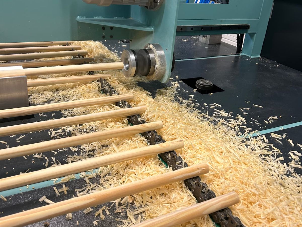 Manici in legno torniti su una macchina circondati da trucioli