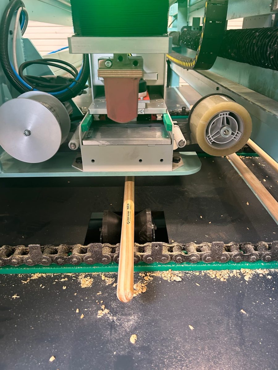 Tampondruckmaschine bedruckt einen Holzstiel mit einer Marke